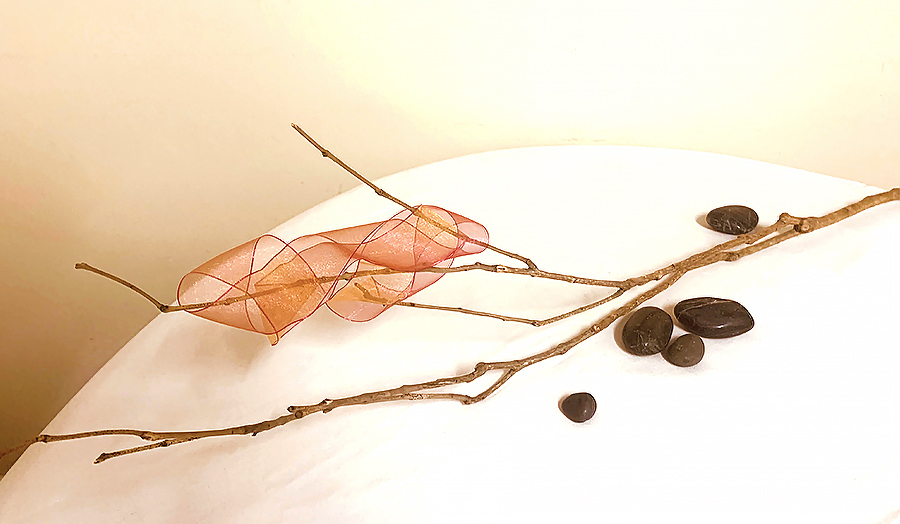 Shan - A very new student use a dried  branch with a chiffon ribbon joined and twisted onto the branch. She used a few pebbles to give weight to the work 